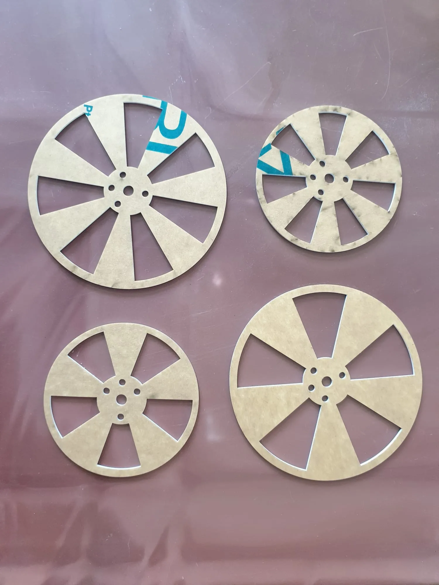 Four discs cut from board, in two diameters and two slot counts, laid out on a sheet.